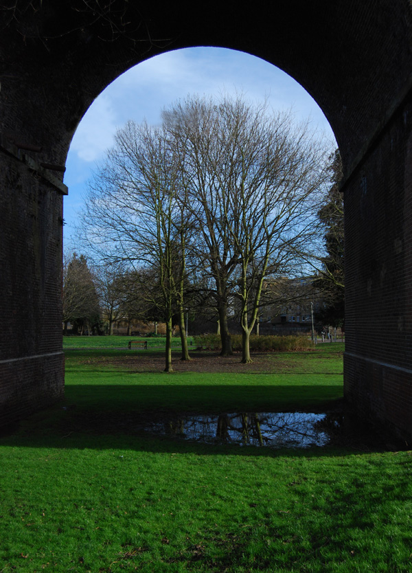 Photo of Central Park framed by the arch of a viaduct